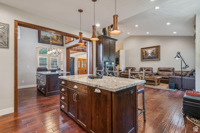 kitchen with a kitchen breakfast bar, dark wood-type flooring, a kitchen island, and open floor plan