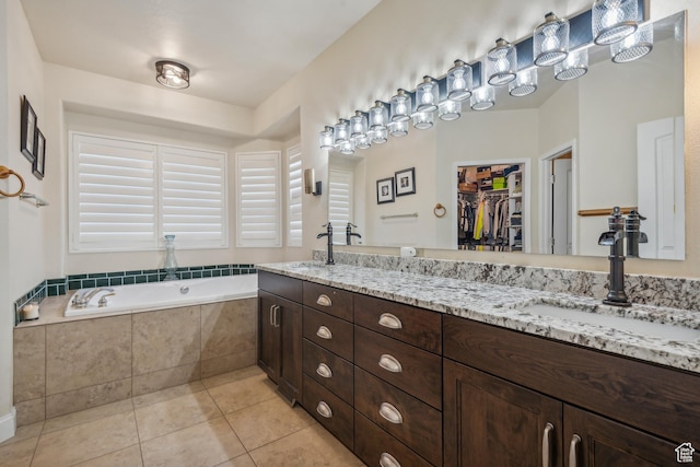 bathroom with a sink, a garden tub, double vanity, and tile patterned flooring