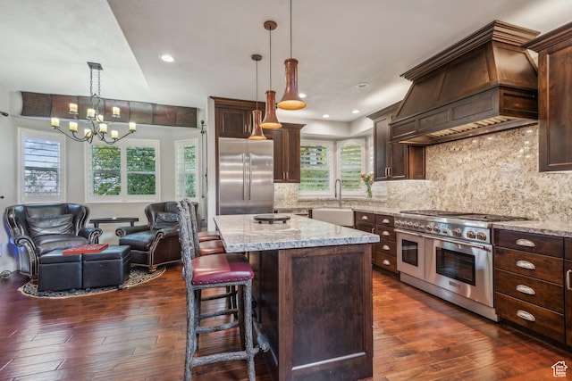 kitchen with dark wood-type flooring, custom range hood, high quality appliances, and open floor plan