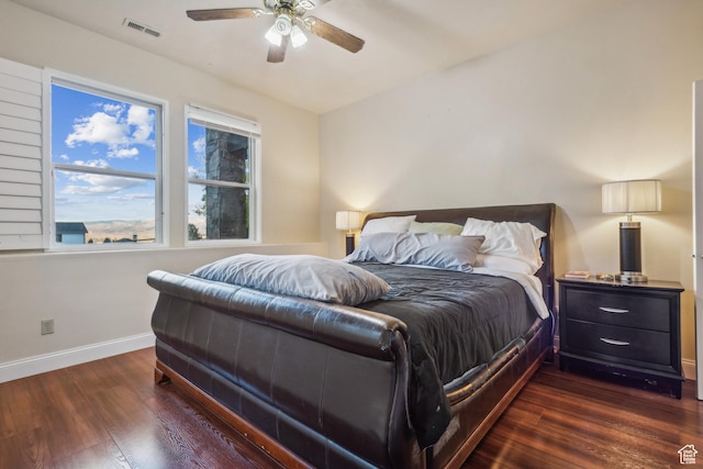 bedroom with baseboards, visible vents, dark wood-style flooring, and ceiling fan