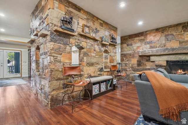 interior space with a stone fireplace, recessed lighting, and wood finished floors