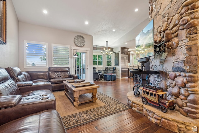 living room featuring a chandelier, recessed lighting, lofted ceiling, and wood finished floors