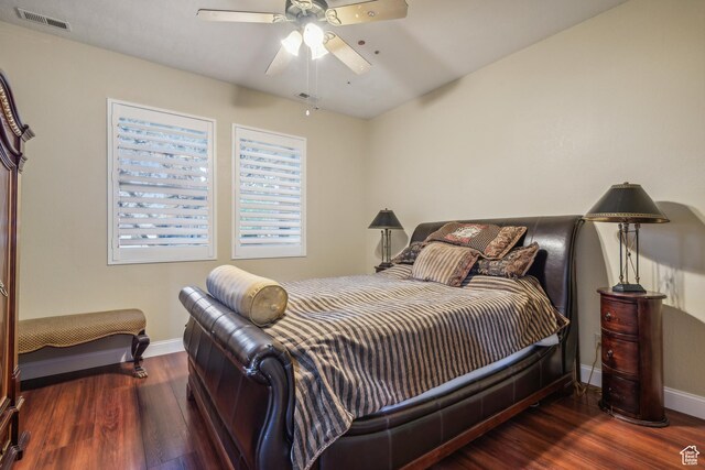 bedroom featuring a ceiling fan, wood finished floors, visible vents, and baseboards