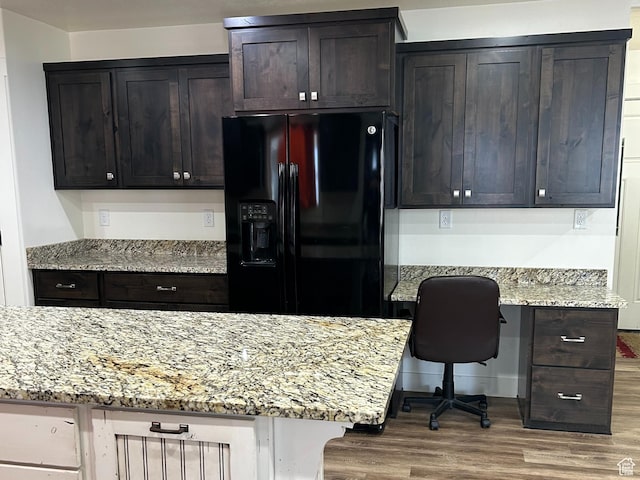 640 S 100 E, Mantua, UT 84324 - kitchen featuring light stone counters, black fridge with ice dispenser, wood finished floors, built in desk, and dark brown cabinetry