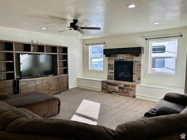 640 S 100 E, Mantua, UT 84324 - living room featuring a ceiling fan, a textured ceiling, carpet, a stone fireplace, and baseboards
