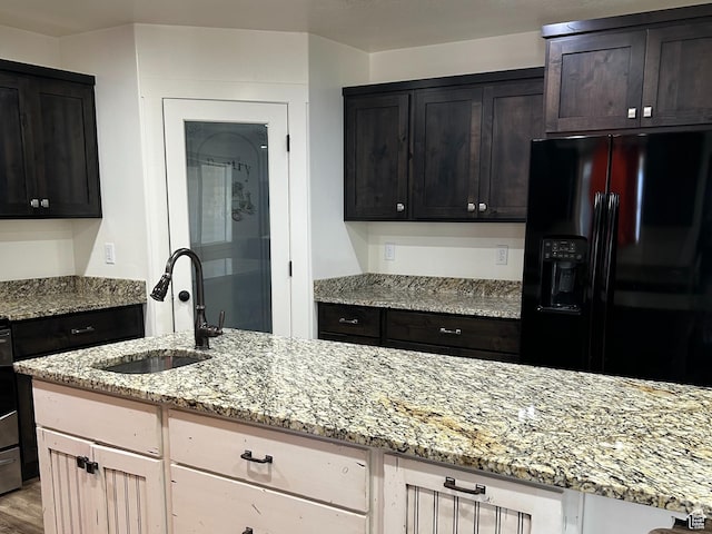 640 S 100 E, Mantua, UT 84324 - kitchen with black fridge, light stone countertops, wood finished floors, and a sink