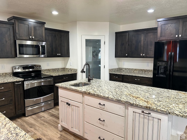 640 S 100 E, Mantua, UT 84324 - kitchen featuring light wood finished floors, light stone counters, appliances with stainless steel finishes, a textured ceiling, and a sink