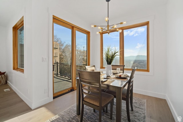 603 N Darwin St E Unit 10, Salt Lake City, UT 84103 - dining room featuring a chandelier, light wood finished floors, and baseboards