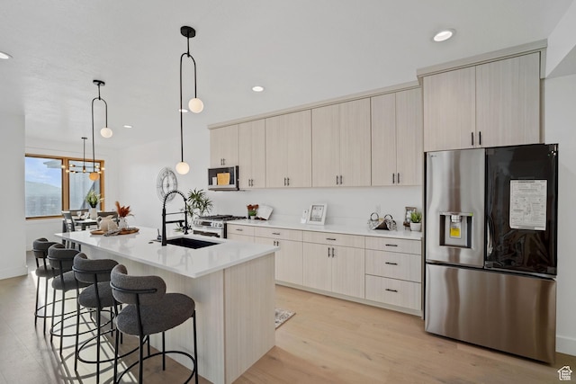 603 N Darwin St E Unit 10, Salt Lake City, UT 84103 - kitchen with a kitchen bar, an island with sink, a sink, stainless steel fridge with ice dispenser, and light countertops