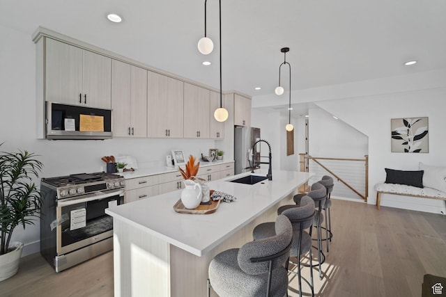 603 N Darwin St E Unit 10, Salt Lake City, UT 84103 - kitchen featuring a breakfast bar, stainless steel appliances, light wood-style floors, and a sink
