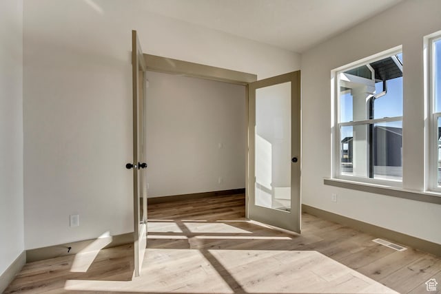 unfurnished bedroom featuring wood finished floors, visible vents, and baseboards