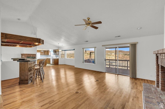 976 N Quail Ridge Dr, Washington, UT 84780 - living room featuring a ceiling fan, visible vents, lofted ceiling, light wood-style flooring, and a brick fireplace