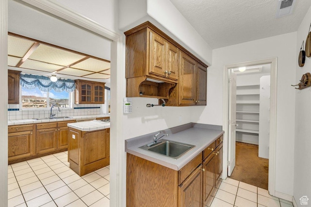 976 N Quail Ridge Dr, Washington, UT 84780 - kitchen with light tile patterned flooring, backsplash, a textured ceiling, and a sink