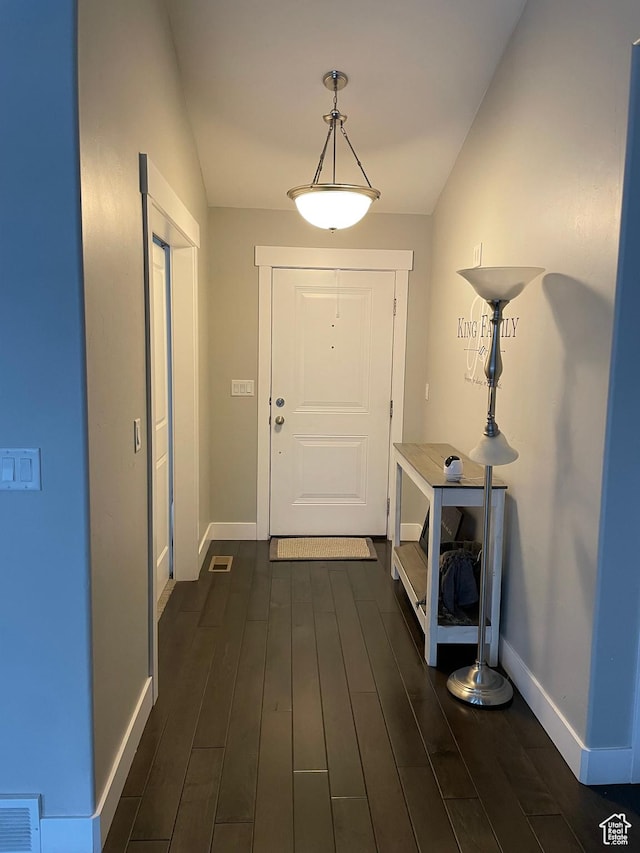 interior space with dark wood-type flooring, baseboards, and visible vents