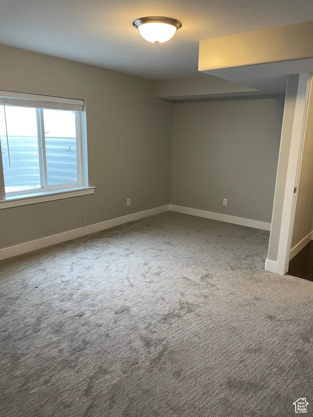 spare room featuring baseboards and carpet