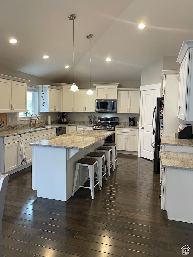 kitchen featuring white cabinetry, a center island, dark wood-style floors, and stainless steel appliances