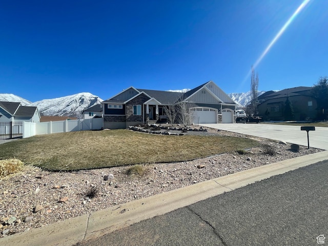 single story home featuring driveway, fence, a mountain view, a front yard, and a garage