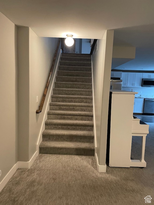 stairs with baseboards and carpet floors