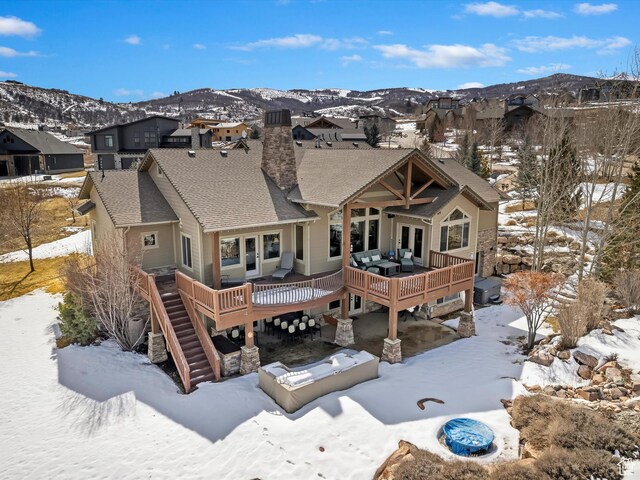 946 S Meadow Lark Ln E, Huntsville, UT 84317 - snow covered back of property with stairway, roof with shingles, a chimney, a deck with mountain view, and a residential view