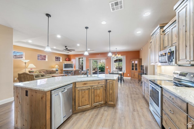 kitchen featuring visible vents, open floor plan, light wood-style flooring, appliances with stainless steel finishes, and a sink