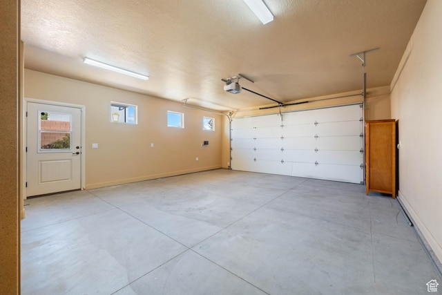 garage featuring a garage door opener and baseboards