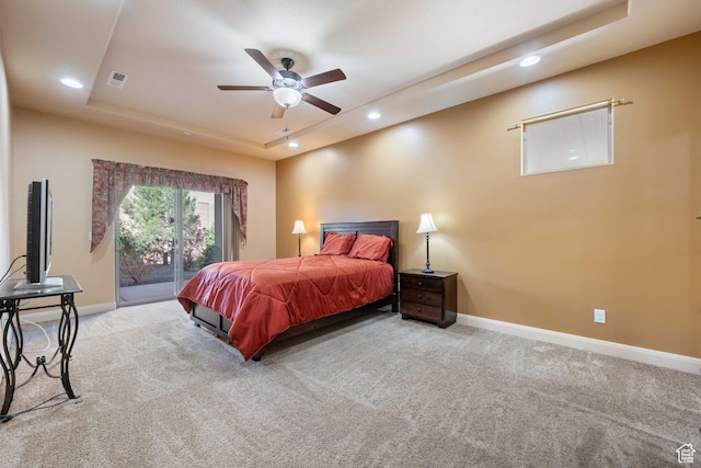 carpeted bedroom with visible vents, baseboards, a tray ceiling, recessed lighting, and access to outside