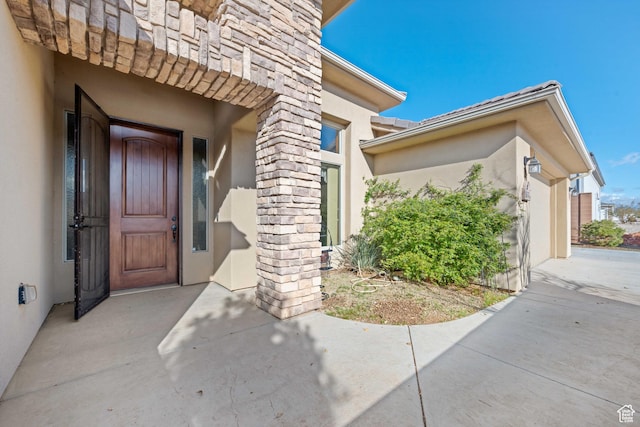 doorway to property with stucco siding and a tiled roof