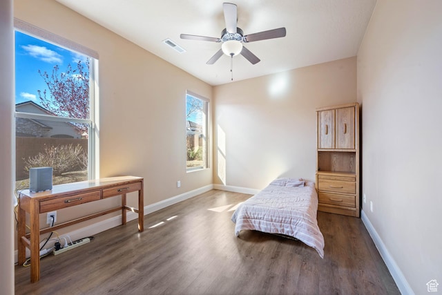 bedroom featuring visible vents, baseboards, wood finished floors, and a ceiling fan