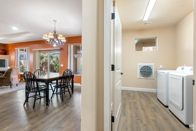 washroom featuring visible vents, a notable chandelier, separate washer and dryer, light wood finished floors, and laundry area