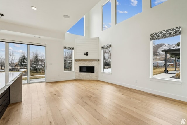 1127 N 520 W Unit 40, Midway, UT 84049 - unfurnished living room featuring a high ceiling, baseboards, a glass covered fireplace, and light wood-type flooring