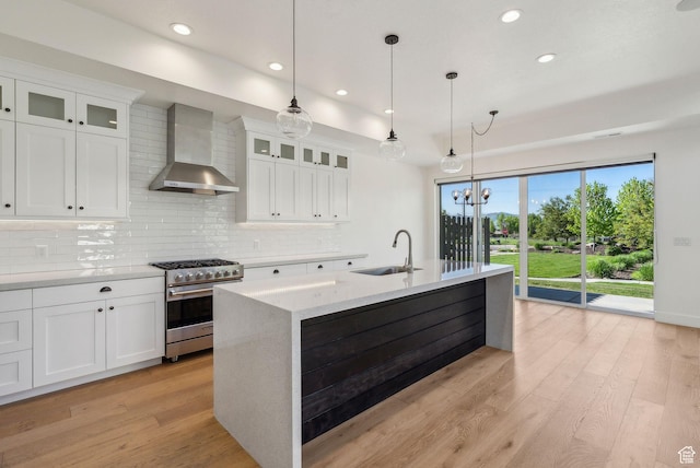 1127 N 520 W Unit 40, Midway, UT 84049 - kitchen with high end range, a sink, wall chimney exhaust hood, decorative backsplash, and light wood-type flooring