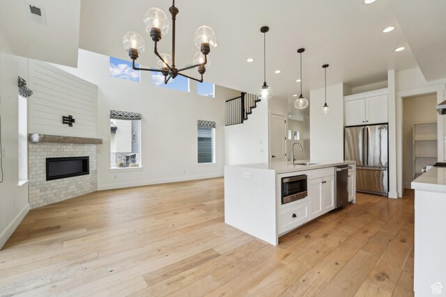 1127 N 520 W Unit 40, Midway, UT 84049 - kitchen with stainless steel appliances, a sink, light wood-type flooring, open floor plan, and white cabinets