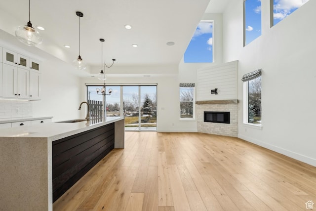 1127 N 520 W Unit 40, Midway, UT 84049 - kitchen featuring a sink, white cabinets, open floor plan, hanging light fixtures, and light wood-style floors
