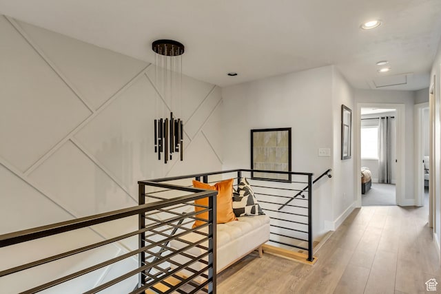 corridor with an upstairs landing, recessed lighting, light wood-style flooring, and baseboards