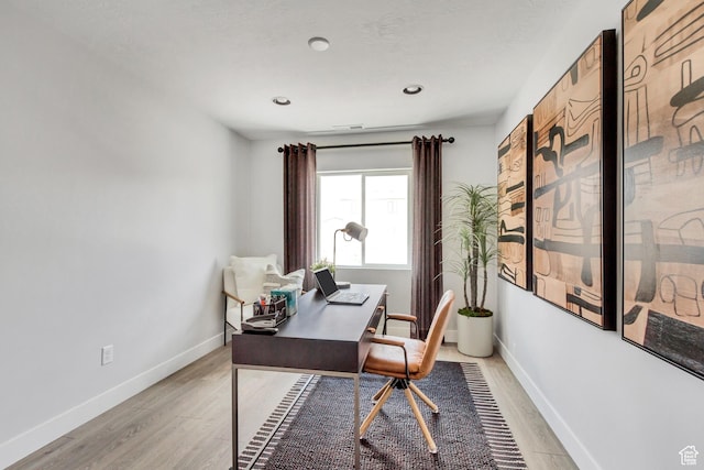 office area featuring visible vents, light wood-style floors, and baseboards