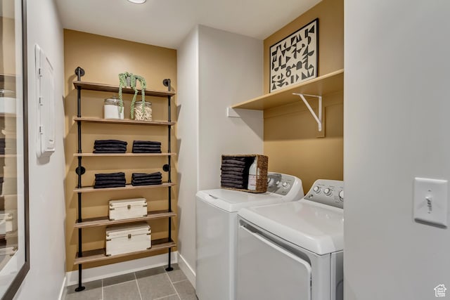 clothes washing area with tile patterned flooring, laundry area, independent washer and dryer, and baseboards