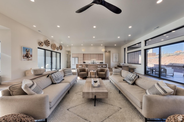 living area with recessed lighting, visible vents, and ceiling fan