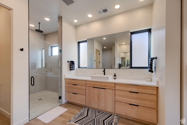 bathroom featuring visible vents, a stall shower, wood finished floors, recessed lighting, and vanity