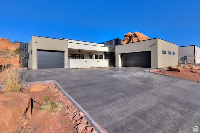 modern home featuring stucco siding, driveway, and an attached garage