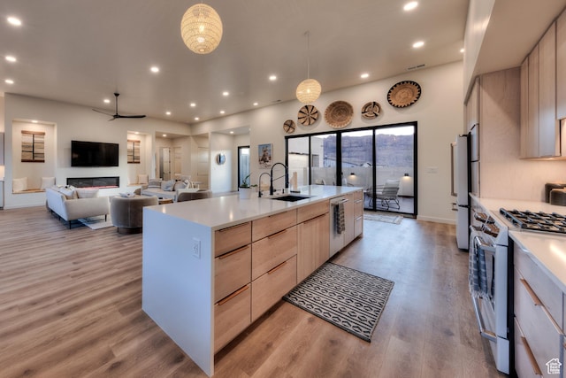 kitchen with recessed lighting, a sink, light brown cabinetry, stainless steel appliances, and modern cabinets