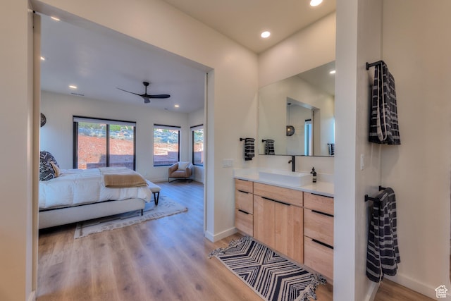 bathroom with vanity, a ceiling fan, wood finished floors, baseboards, and connected bathroom