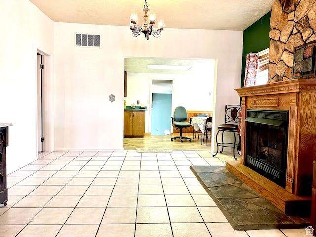 439 E 400 S, Vernal, UT 84078 - living area with visible vents, a fireplace with raised hearth, a chandelier, and light tile patterned flooring