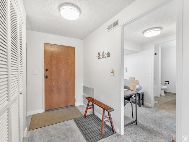 521 E 5th Ave Unit 605, Salt Lake City, UT 84103 - foyer entrance featuring visible vents, baseboards, carpet, and a textured ceiling