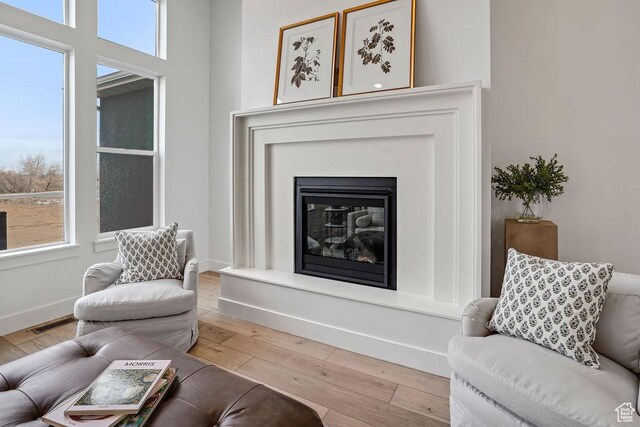 2878 W 2850 S, West Haven, UT 84401 - living area with light wood finished floors, visible vents, baseboards, and a glass covered fireplace