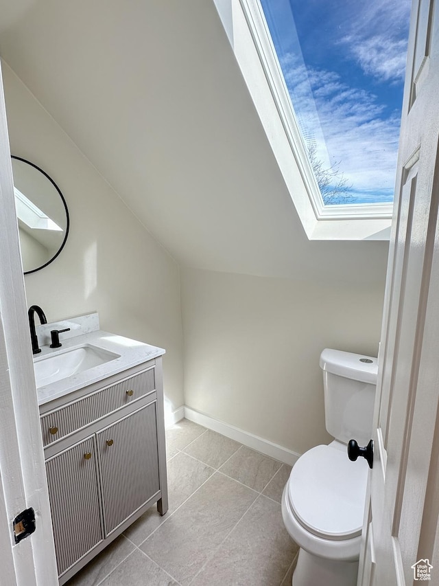 120 S 200 E, Castle Dale, UT 84513 - half bathroom with vanity, baseboards, lofted ceiling with skylight, toilet, and tile patterned floors