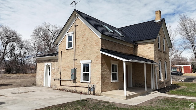 120 S 200 E, Castle Dale, UT 84513 - back of property with brick siding, covered porch, a chimney, and metal roof