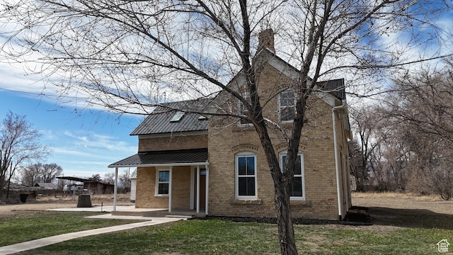 120 S 200 E, Castle Dale, UT 84513 - view of front facade with a front yard, brick siding, and metal roof