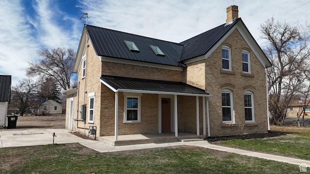 120 S 200 E, Castle Dale, UT 84513 - view of front of home featuring driveway, a porch, a chimney, brick siding, and metal roof