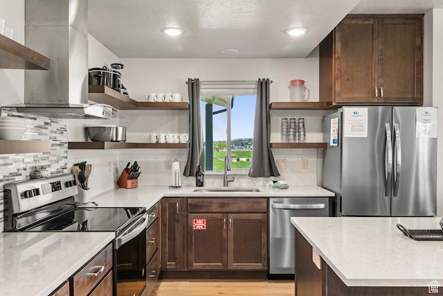 140 W 150th St S Unit D12, Garden City, UT 84028 - kitchen with open shelves, light wood-style floors, stainless steel appliances, wall chimney exhaust hood, and a sink