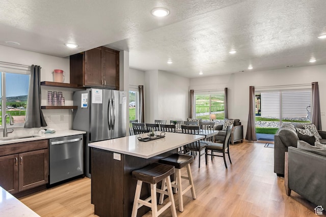 140 W 150th St S Unit D12, Garden City, UT 84028 - kitchen with a breakfast bar, open shelves, a sink, stainless steel appliances, and dark brown cabinets